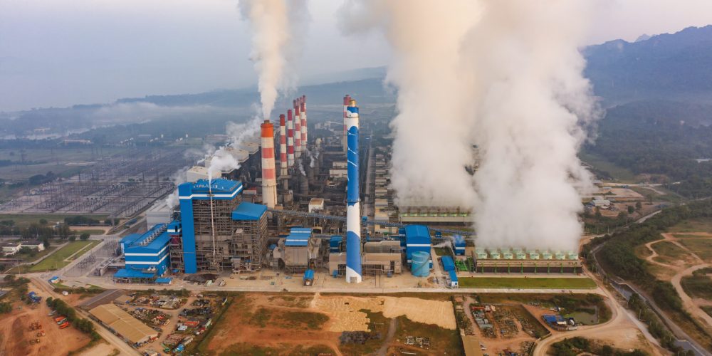 Aerial view of Mae Moh Coal Power Plant with smoke and toxic air from chimney. Factory industry. Electricity tower in energy or pollution environment concept. Lampang City, Thailand